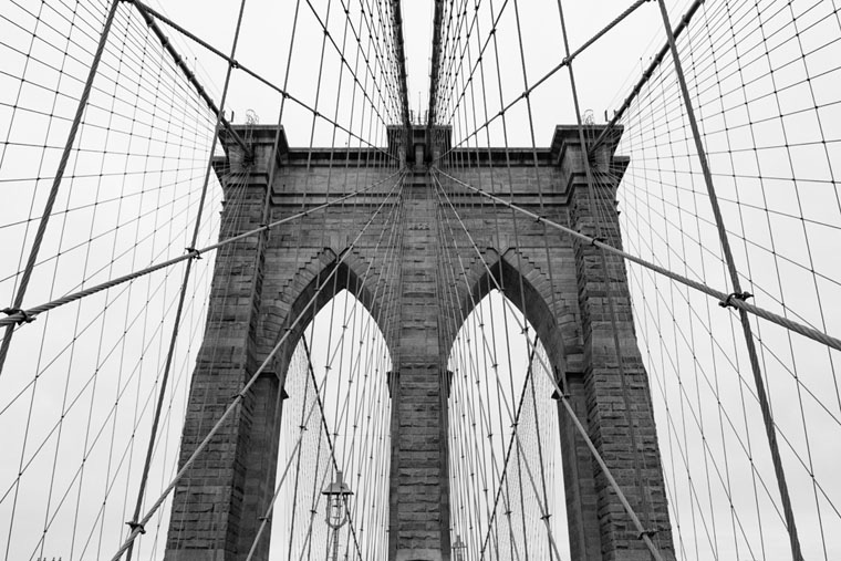 A black and white shot of one of the towers of the Brooklyn Bridge