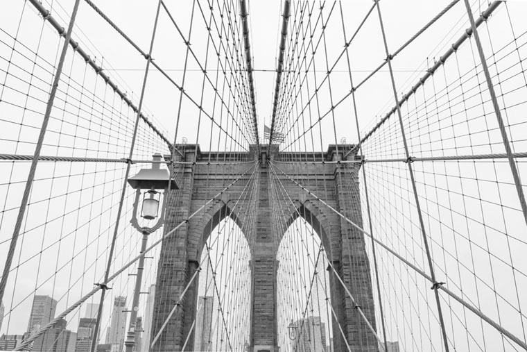 A black and white shot of one of the towers of the Brooklyn Bridge
